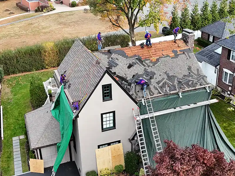 Crew removing shingles from roof